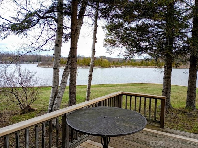 wooden deck with a lawn and a water view