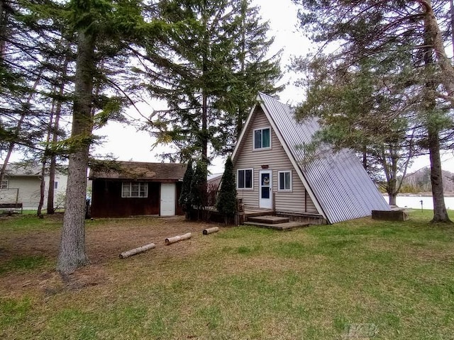 back of house featuring an outbuilding and a yard