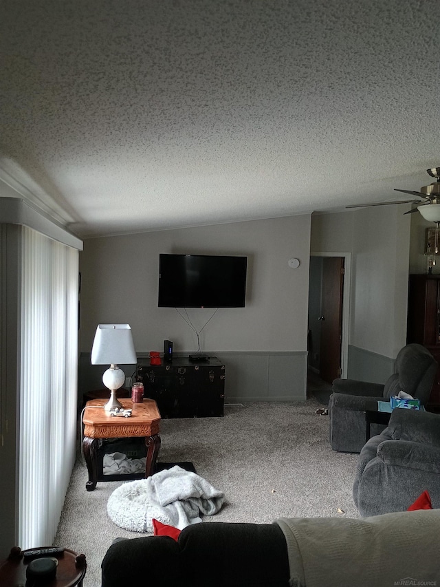 living room with carpet flooring, a textured ceiling, and a ceiling fan