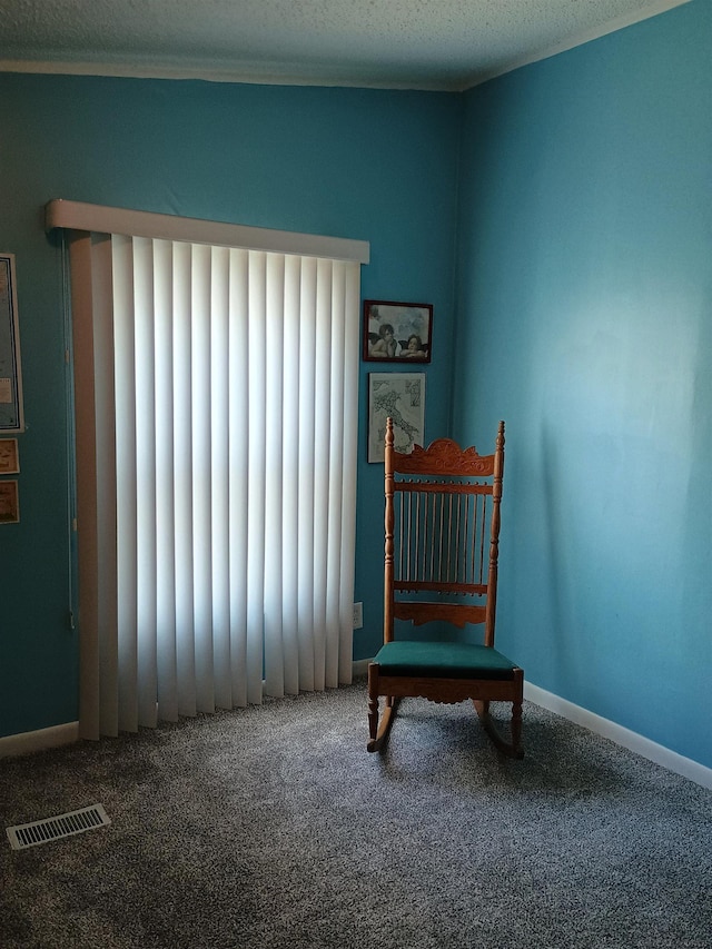 sitting room with visible vents, radiator, baseboards, a textured ceiling, and carpet