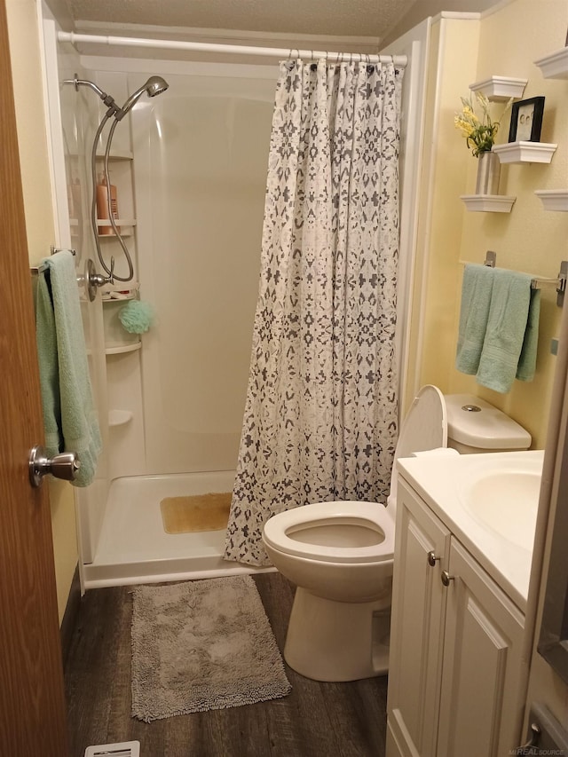full bath featuring toilet, a shower stall, wood finished floors, and vanity