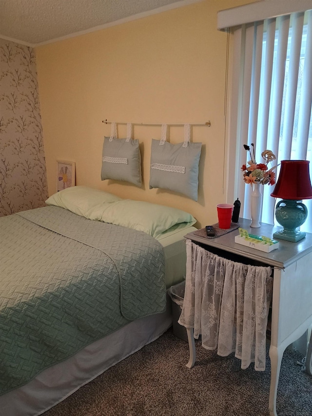 bedroom with carpet floors, a textured ceiling, wallpapered walls, and ornamental molding