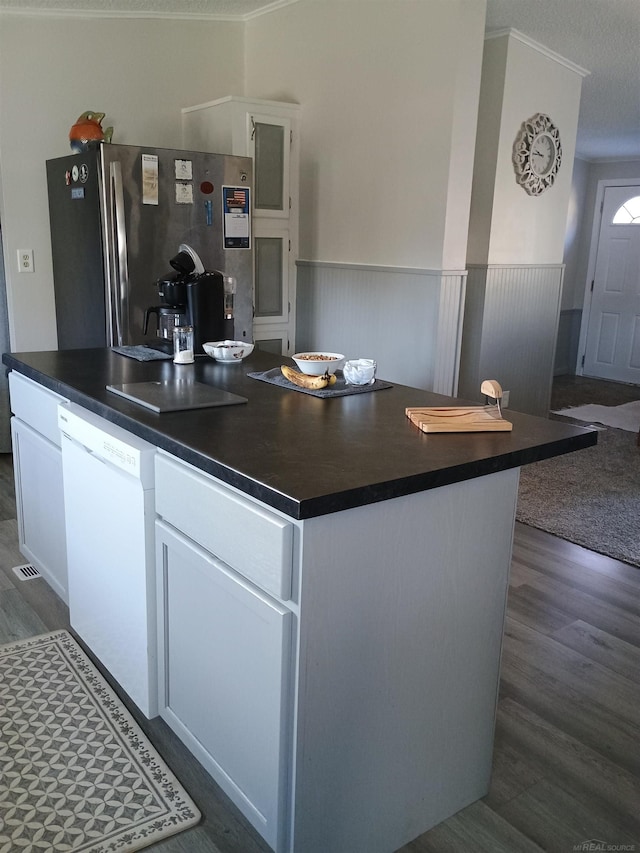 kitchen featuring freestanding refrigerator, dark wood-style flooring, dark countertops, and dishwasher