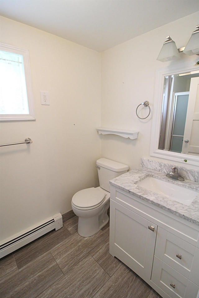 full bath with a baseboard radiator, vanity, toilet, wood finished floors, and a shower