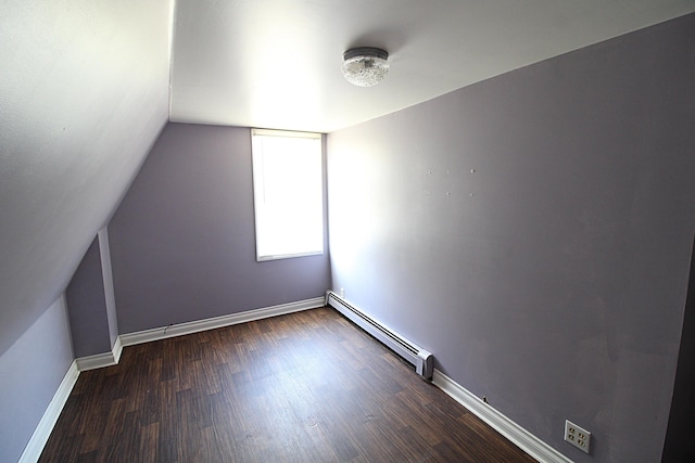 additional living space featuring baseboards, a baseboard heating unit, lofted ceiling, and dark wood-type flooring
