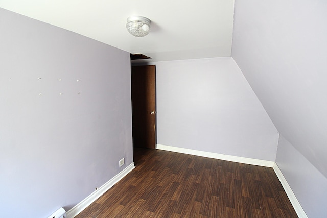unfurnished room featuring baseboards, a baseboard heating unit, and wood finished floors