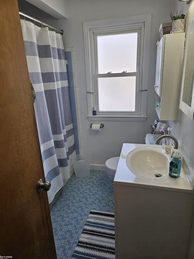 full bathroom featuring toilet, a shower with curtain, baseboards, and vanity