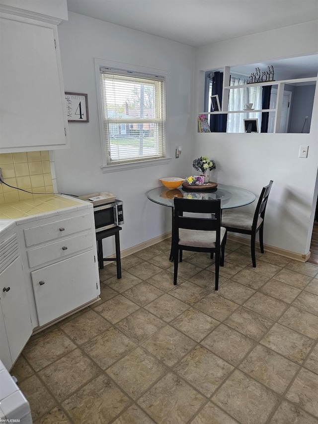 dining room with baseboards, stone finish floor, and breakfast area
