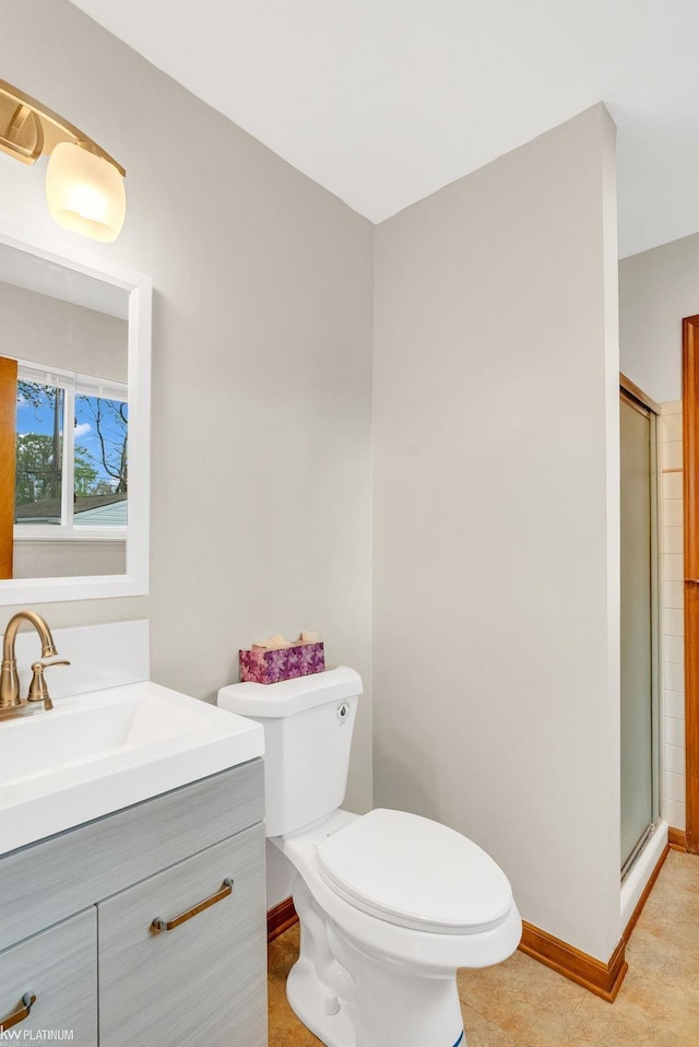 full bath featuring baseboards, a shower with door, toilet, and vanity