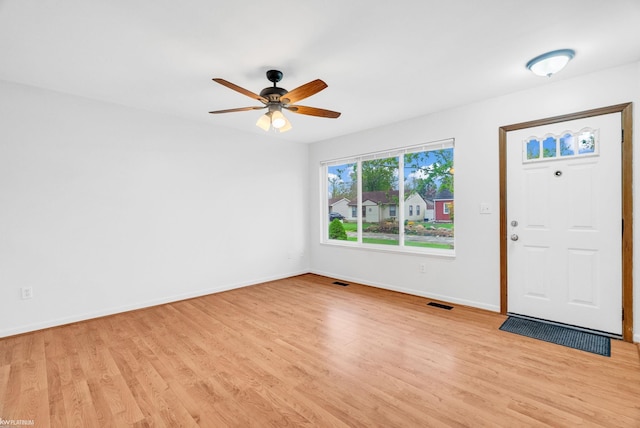 entryway with baseboards, visible vents, ceiling fan, and light wood-type flooring