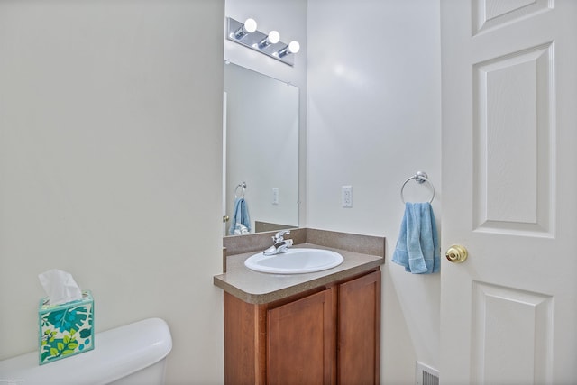 bathroom with visible vents, toilet, and vanity