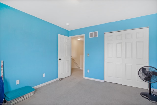 interior space with a closet, baseboards, carpet flooring, and visible vents