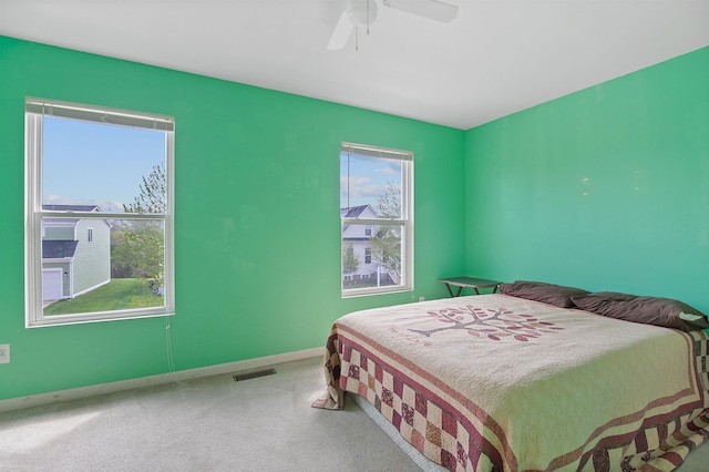 bedroom featuring carpet floors, baseboards, visible vents, and ceiling fan