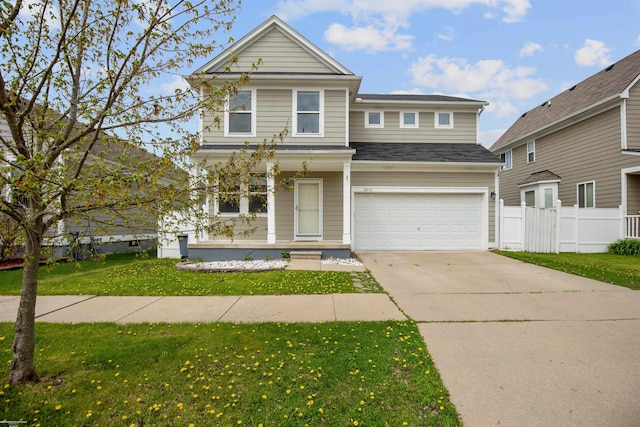 traditional home featuring a garage, fence, a front lawn, concrete driveway, and a shingled roof