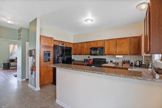 kitchen featuring visible vents, a peninsula, brown cabinets, and black appliances