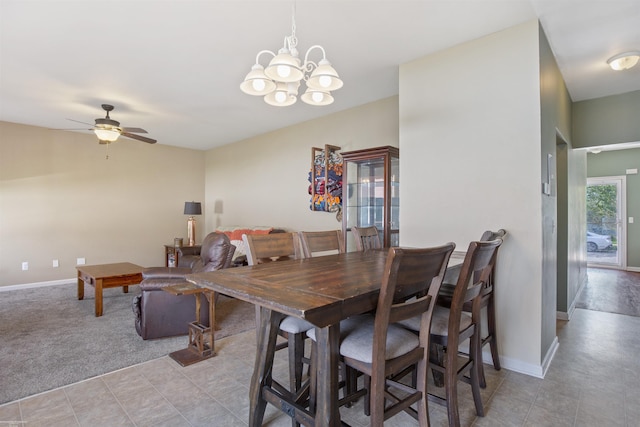 dining area with baseboards and ceiling fan with notable chandelier
