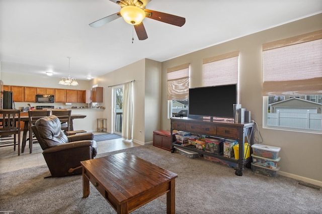 living area with baseboards, light carpet, ceiling fan with notable chandelier, and visible vents