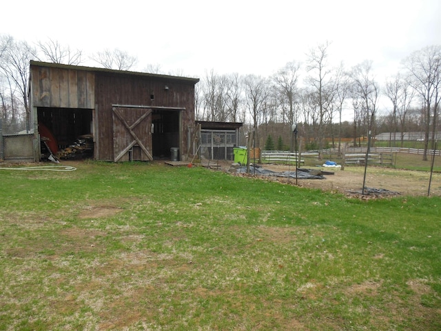 view of outdoor structure featuring fence and an outbuilding