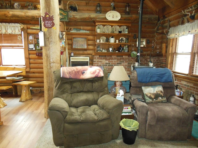 living room with rustic walls, vaulted ceiling, wood finished floors, and a wood stove