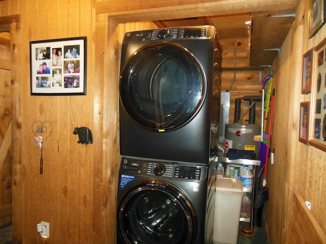 washroom with laundry area, wood walls, and stacked washer / dryer