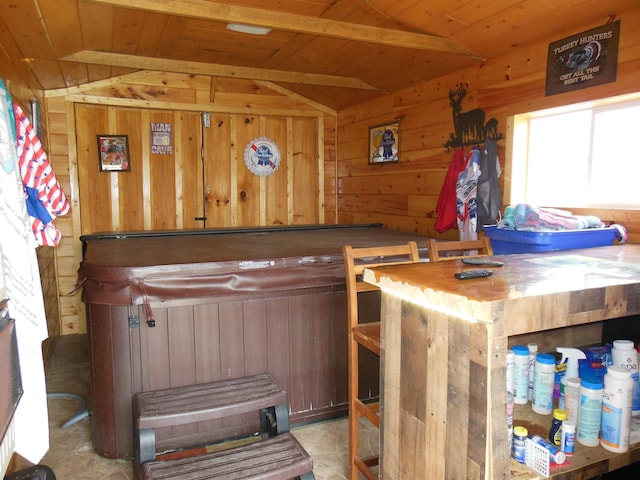 bar featuring vaulted ceiling with beams, wood walls, wood ceiling, and a bar