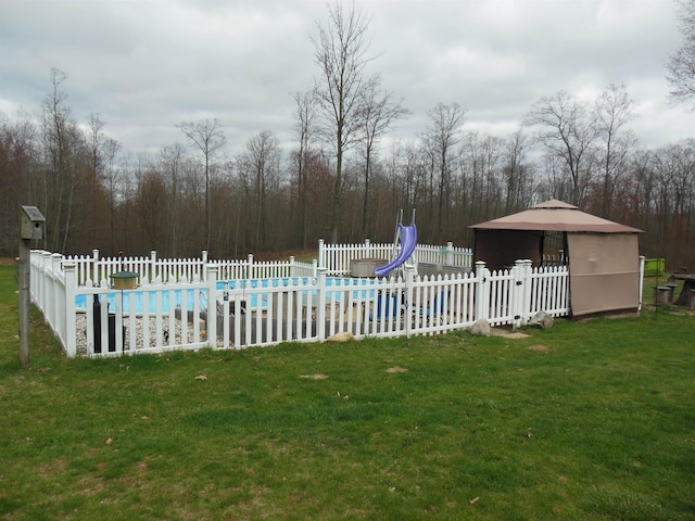 view of pool featuring a yard, fence, a water slide, and a fenced in pool