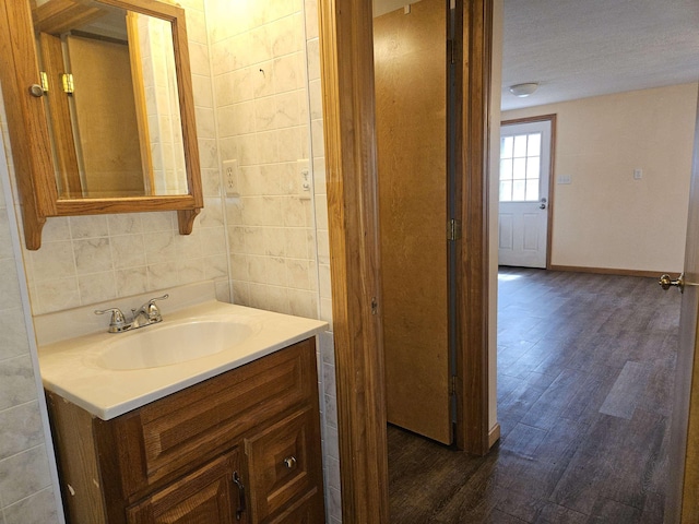 bathroom with baseboards, wood finished floors, and vanity