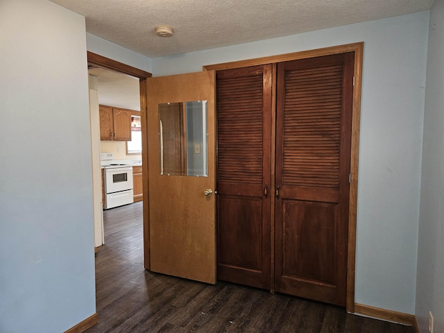 interior space with light countertops, baseboards, white electric range, and dark wood-style flooring