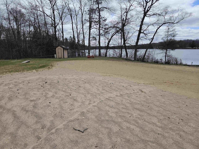 view of home's community featuring a storage unit, a water view, and an outdoor structure