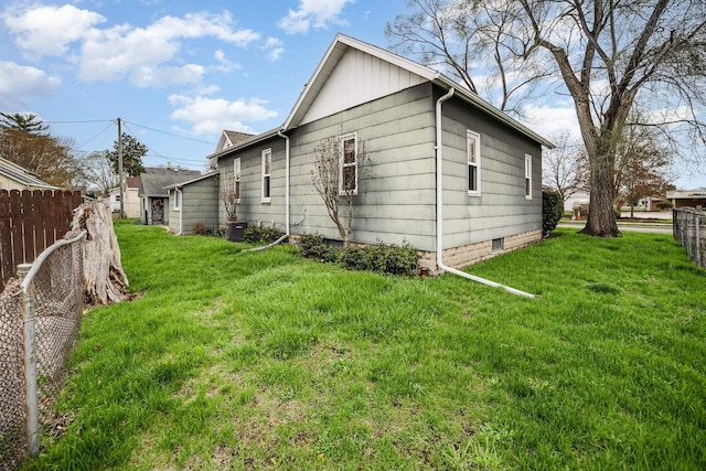 view of side of property with a lawn, fence, and cooling unit
