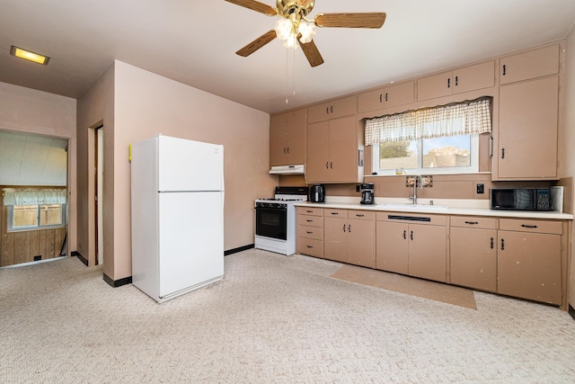 kitchen with range with gas stovetop, freestanding refrigerator, black microwave, cream cabinetry, and a sink