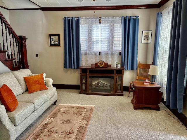 carpeted living area featuring stairs, a ceiling fan, baseboards, and ornamental molding
