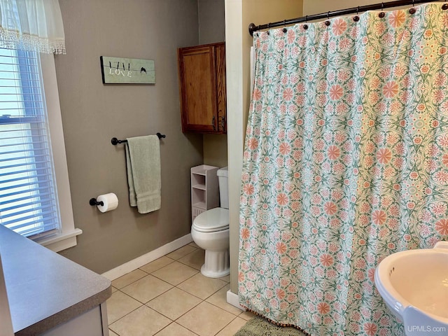 full bath featuring tile patterned floors, baseboards, toilet, and curtained shower
