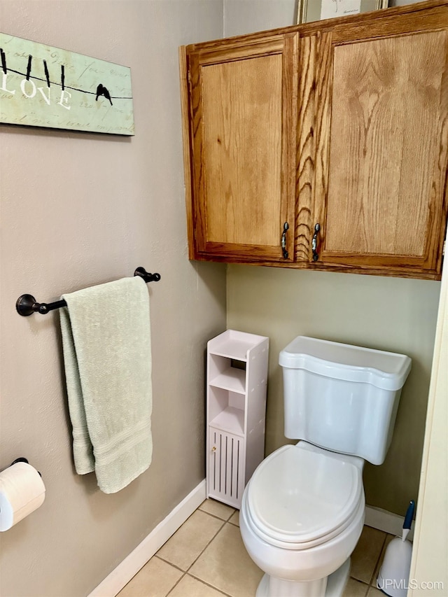 bathroom with baseboards, tile patterned flooring, and toilet