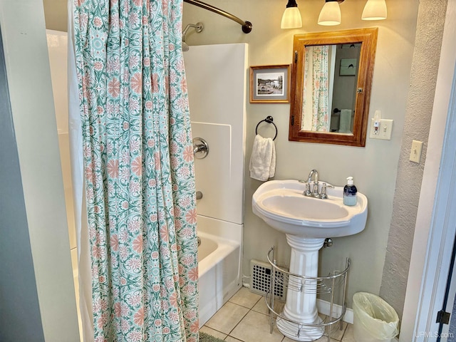 bathroom with shower / bath combo with shower curtain and tile patterned flooring