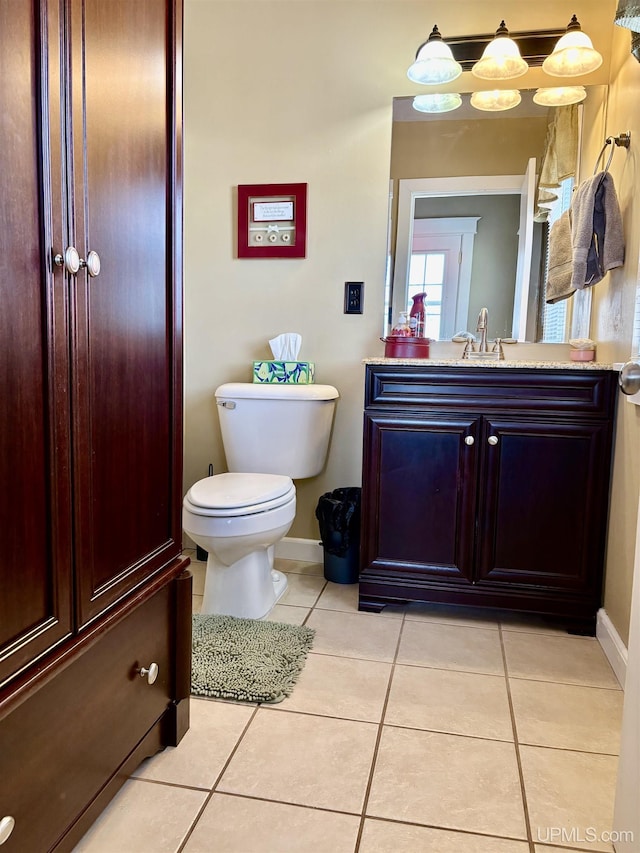 bathroom with vanity, tile patterned flooring, baseboards, and toilet