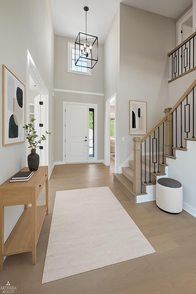3251 Waldon Ridge Dr, Orion Twp, MI 48359 - foyer featuring a towering ceiling, plenty of natural light, stairway, a chandelier, and baseboards