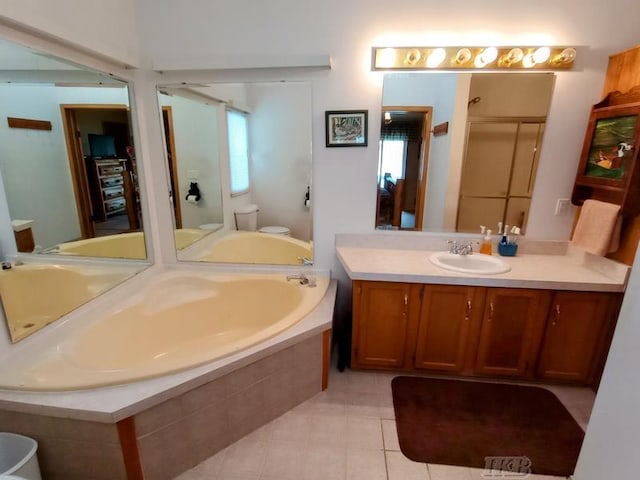 full bath featuring tile patterned flooring, vanity, toilet, a bath, and a stall shower