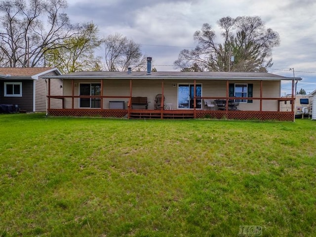 rear view of property featuring a lawn and a deck