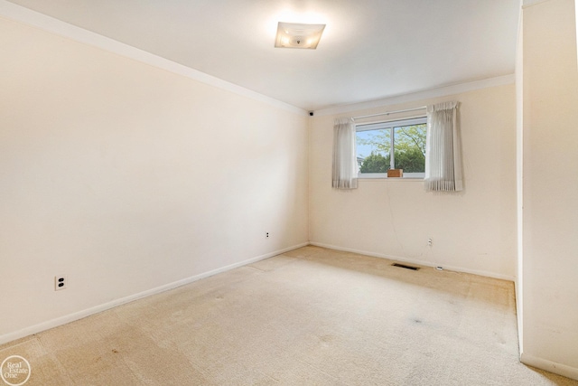 spare room featuring visible vents, carpet, crown molding, and baseboards