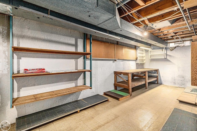 unfinished basement with a workshop area and tile patterned floors
