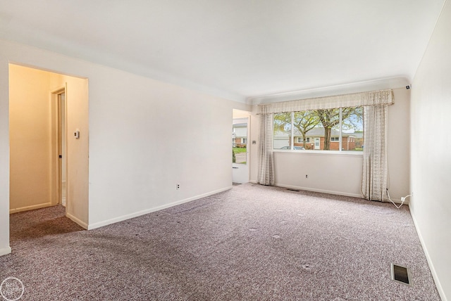 carpeted spare room with baseboards and visible vents