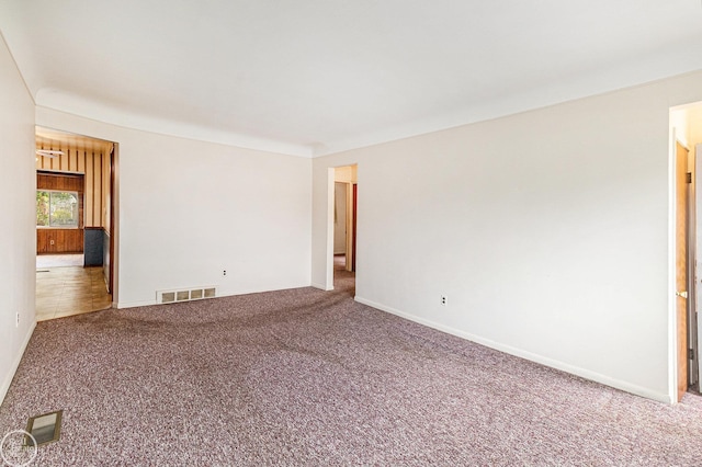 carpeted spare room with baseboards and visible vents