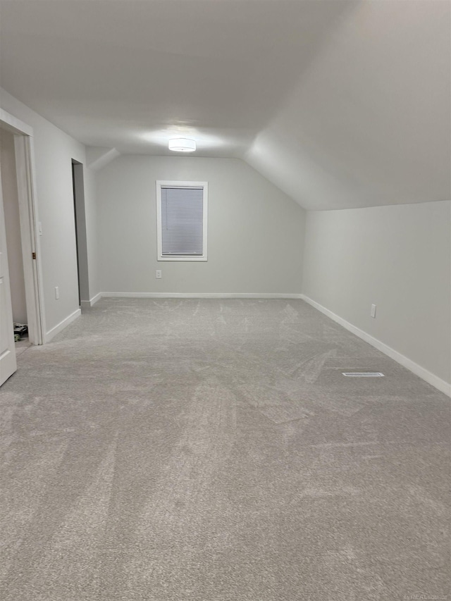 bonus room with carpet floors, baseboards, and lofted ceiling
