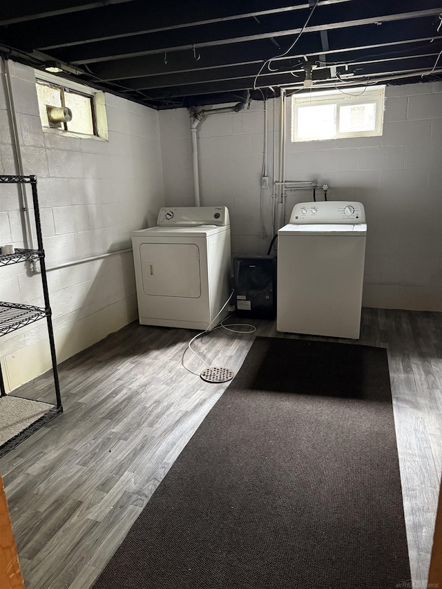 washroom with laundry area, washing machine and dryer, and wood finished floors