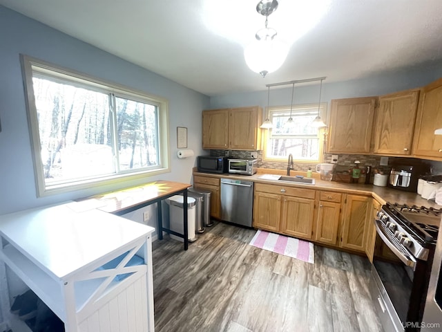 131 Midway Dr, Negaunee, MI 49866 - kitchen with stainless steel appliances, a sink, decorative backsplash, wood finished floors, and light countertops