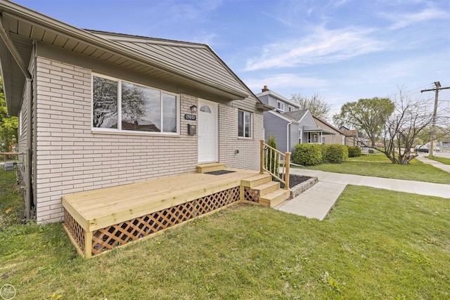 exterior space with brick siding and a front yard