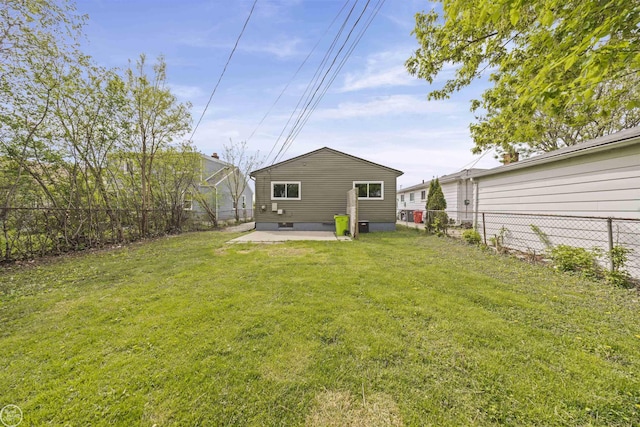rear view of property featuring a fenced backyard, a patio area, and a yard