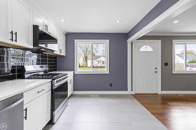 kitchen with white cabinetry, baseboards, appliances with stainless steel finishes, and tasteful backsplash