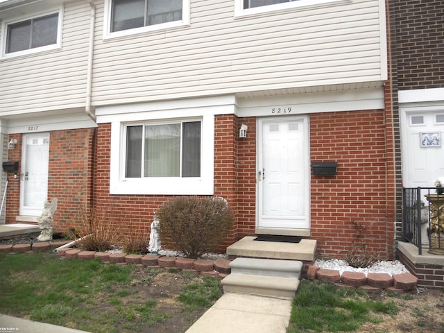 view of exterior entry featuring brick siding